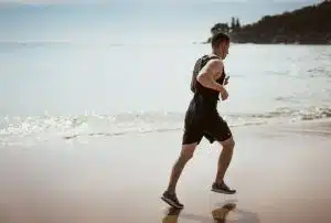 Man running on the beach to naturally increase his testosterone